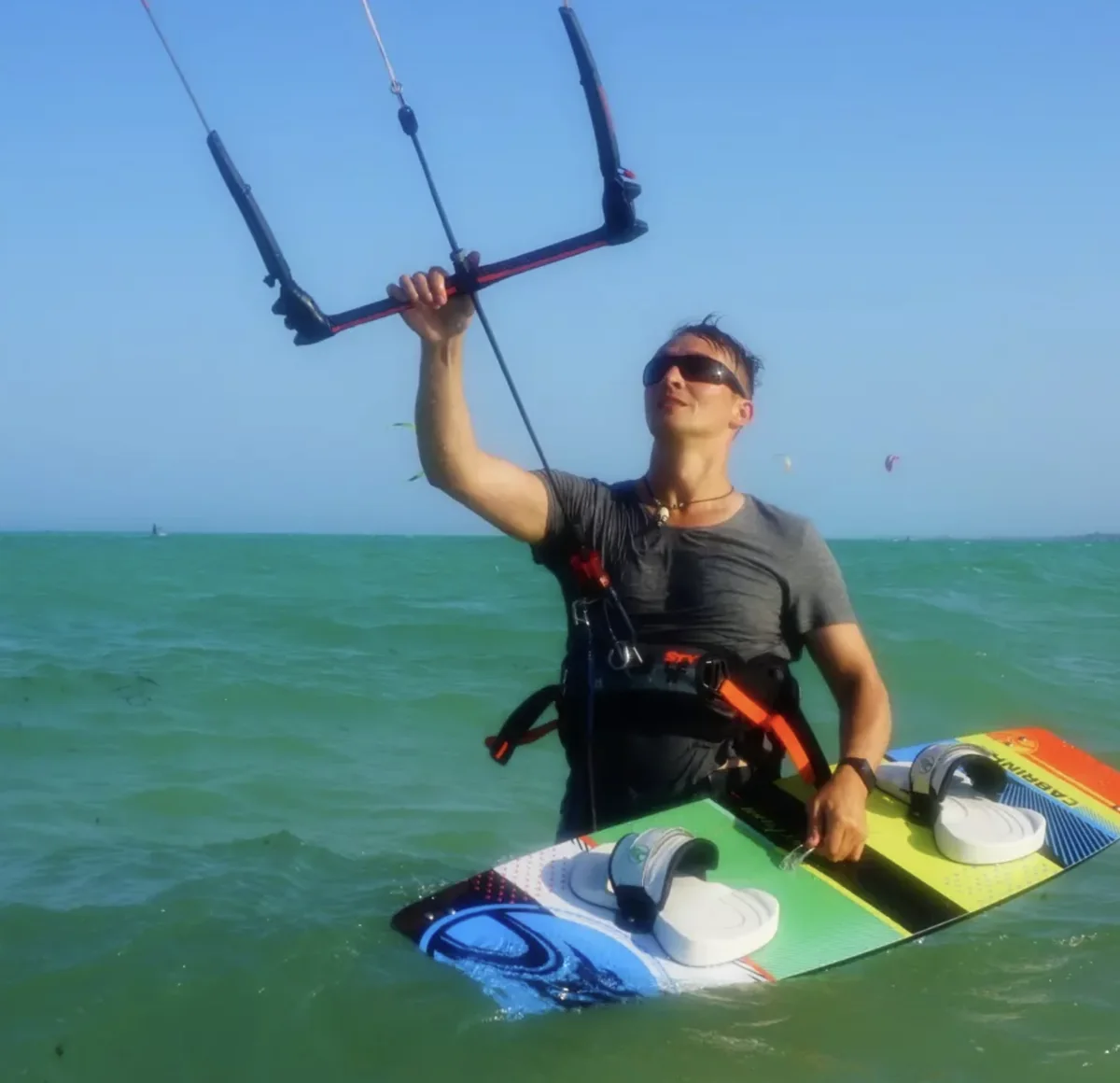 Kirill standing in the sea with a kite and board